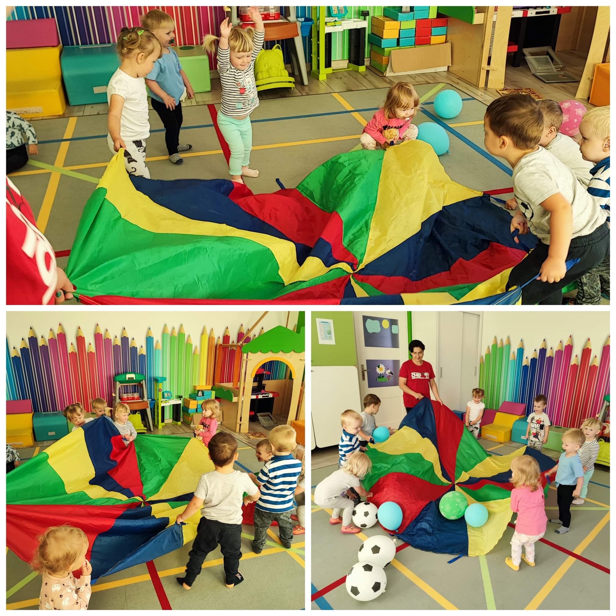 Grupa dzieci bawi się kolorową chustą animacyjną w sali z dekoracjami w postaci kredek na ścianie, piłkami i kolorowymi meblami.