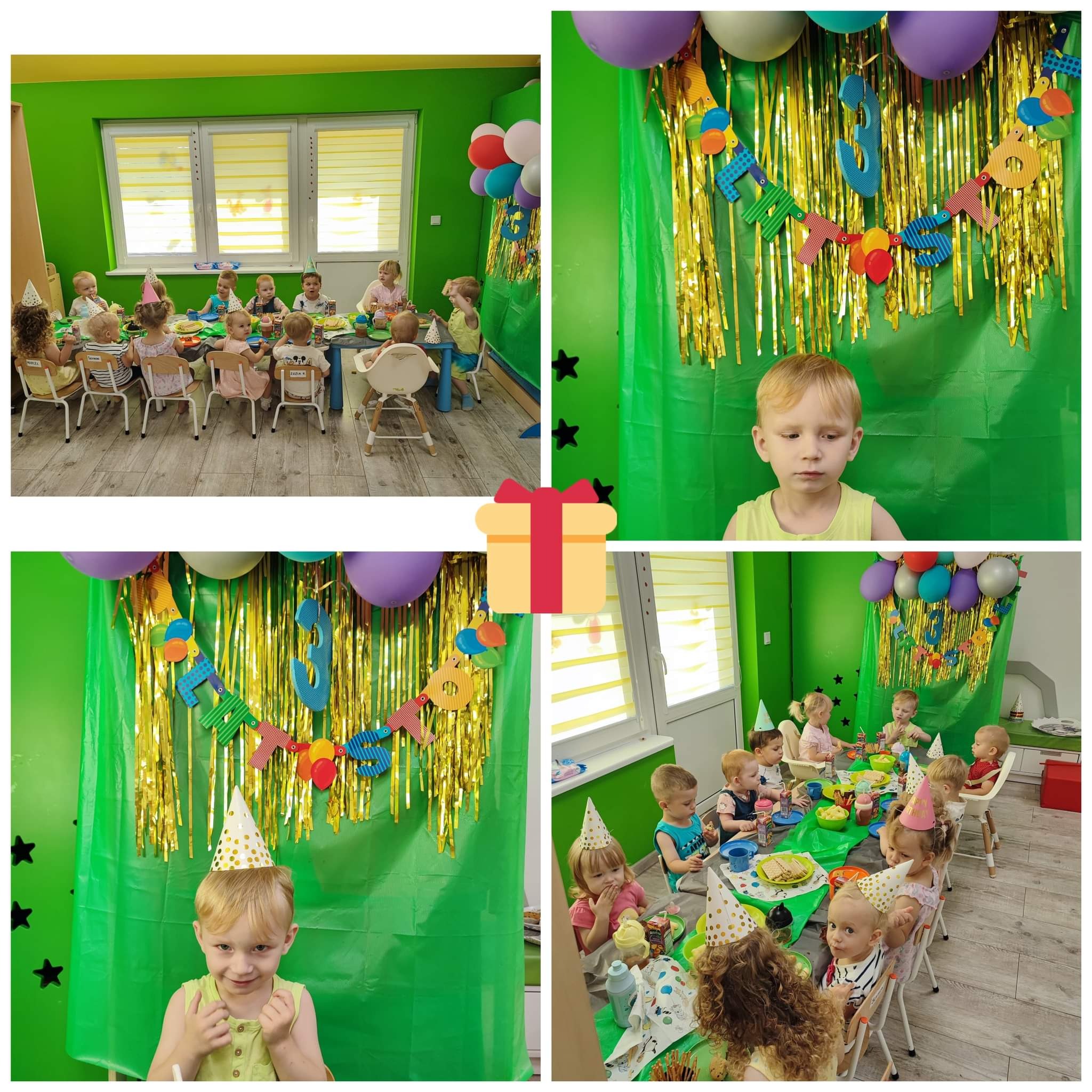 Sala udekorowana na przyjęcie urodzinowe dla dzieci, z zielonymi ścianami, balonami, złotymi frędzlami i napisem 'Happy Birthday'. Dzieci w papierowych czapeczkach siedzą przy stole z przekąskami.