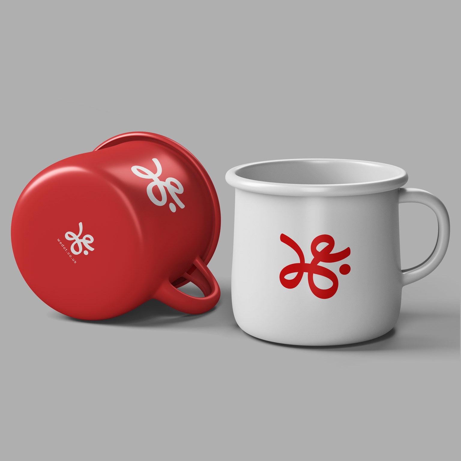 Dwa emaliowane kubki: czerwony leżący i biały stojący, oba z czerwonym logo na szarym tle.