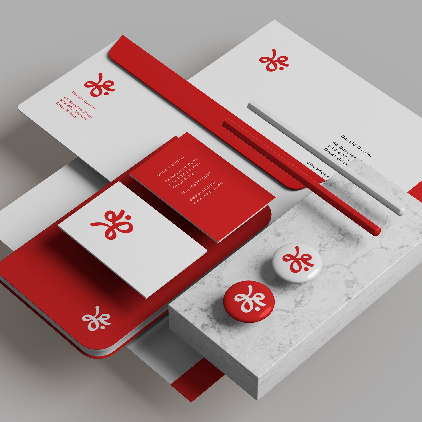 Zestaw materiałów identyfikacyjnych firmy Donald Dumier: wizytówki, papier firmowy, notatnik, dwa przypinki z logo, ułożone na abstrakcyjnym tle z elementami marmuru i czerwieni.