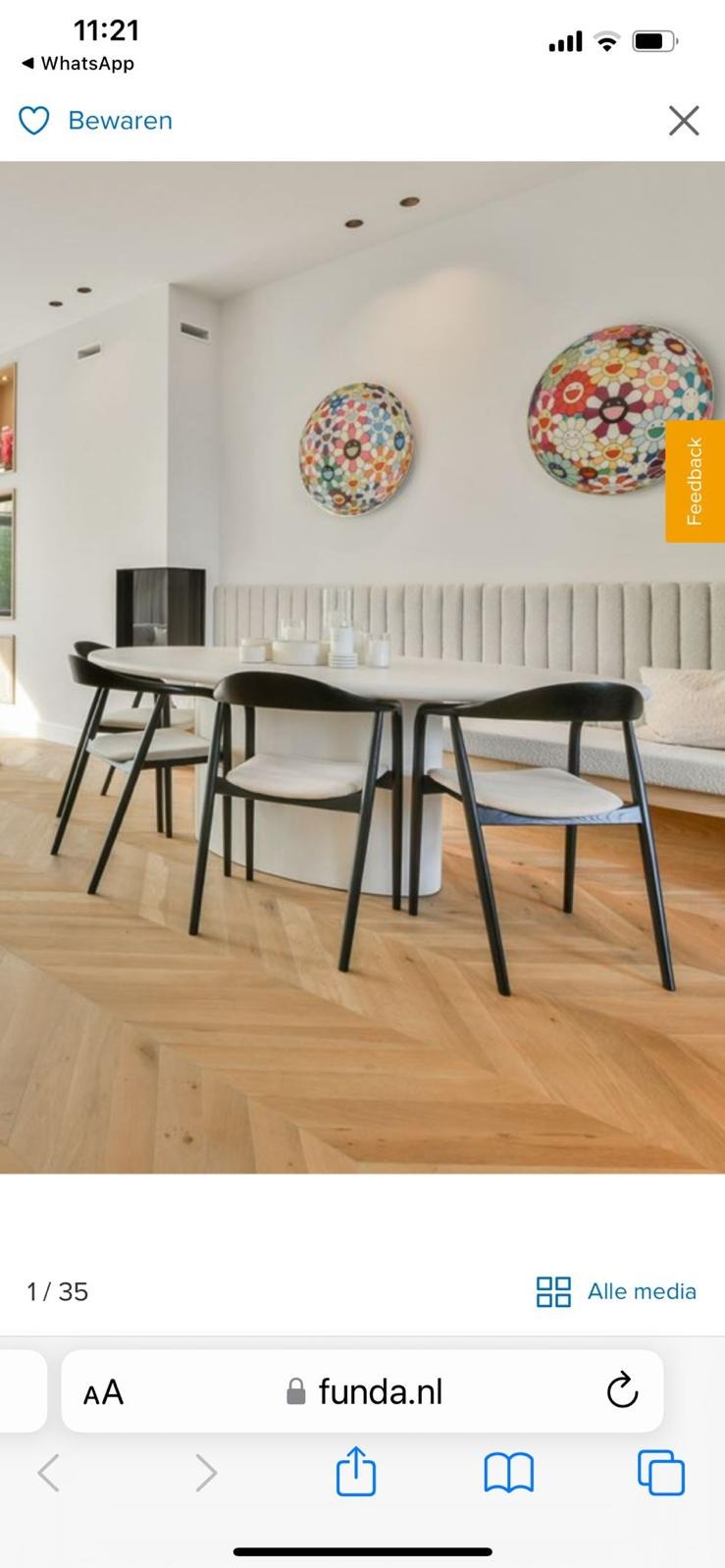 Jasny parkiet ułożony w jodełkę francuską w nowoczesnej jadalni z okrągłym stołem i czarnymi krzesłami. Na ścianie dekoracyjne, kolorowe obrazy.