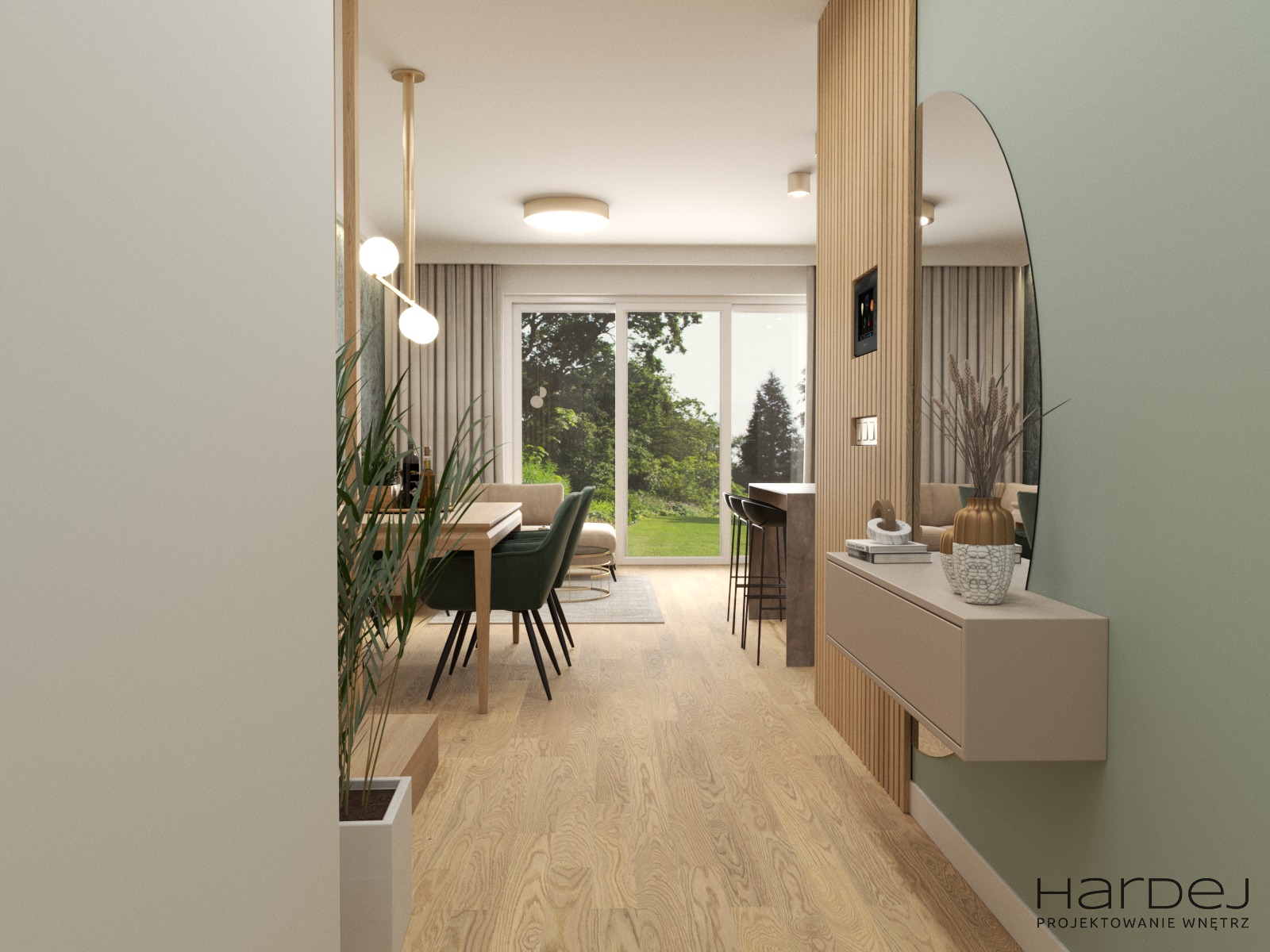 Wnętrze mieszkania z drewnianą podłogą, stołem z zielonymi krzesłami, barkiem z hokerami i konsolą z owalnym lustrem, widok zza rośliny w donicy.