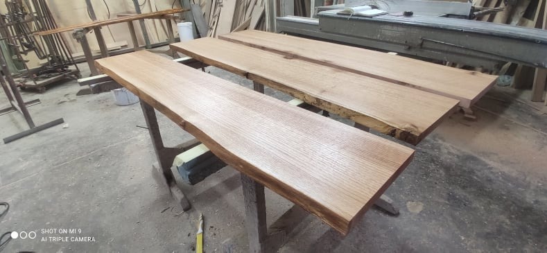 Surowe, drewniane parapety z naturalną krawędzią, przygotowane do dalszej obróbki w warsztacie w Stalowej Woli. Widoczne sęki i naturalne usłojenie drewna.