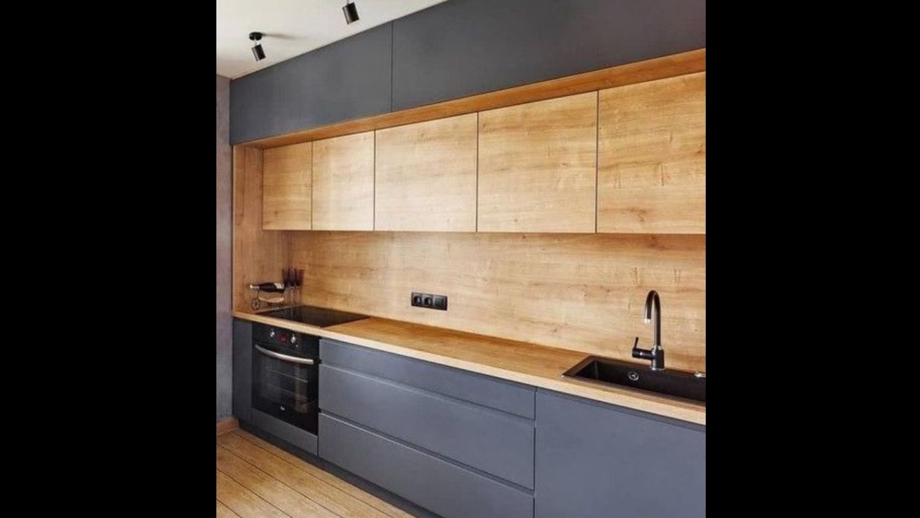 Nowoczesna kuchnia z szarymi szafkami dolnymi i górnymi z drewnopodobnym frontem, czarny zlew i płyta indukcyjna, oświetlenie punktowe.