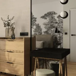 Nowoczesna sypialnia z drewnianą komodą, czarnym biurkiem i tapetą z motywem lasu, oświetlona okrągłymi lampami ściennymi i lampką biurkową.
