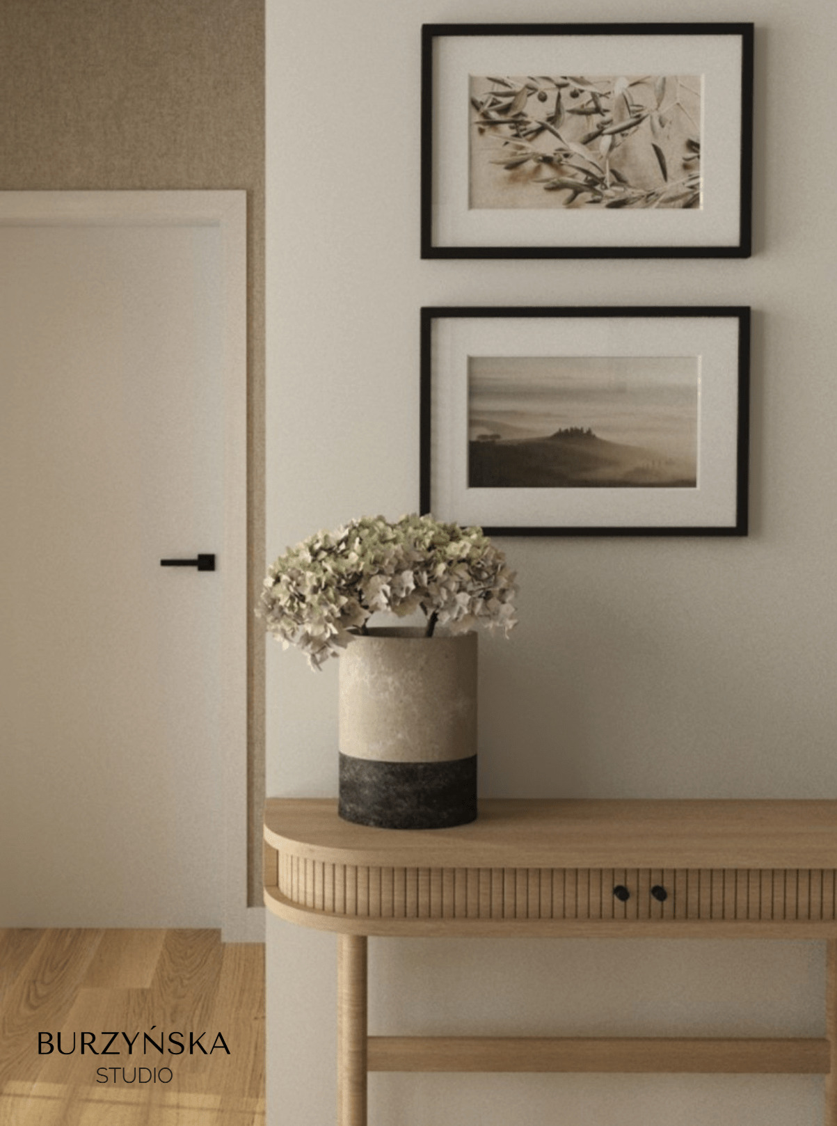 Beżowe wnętrze: konsola z ryflowanym frontem szuflady, wazon z hortensjami, grafiki w czarnych ramkach na ścianie, minimalistyczne drzwi z czarną klamką.