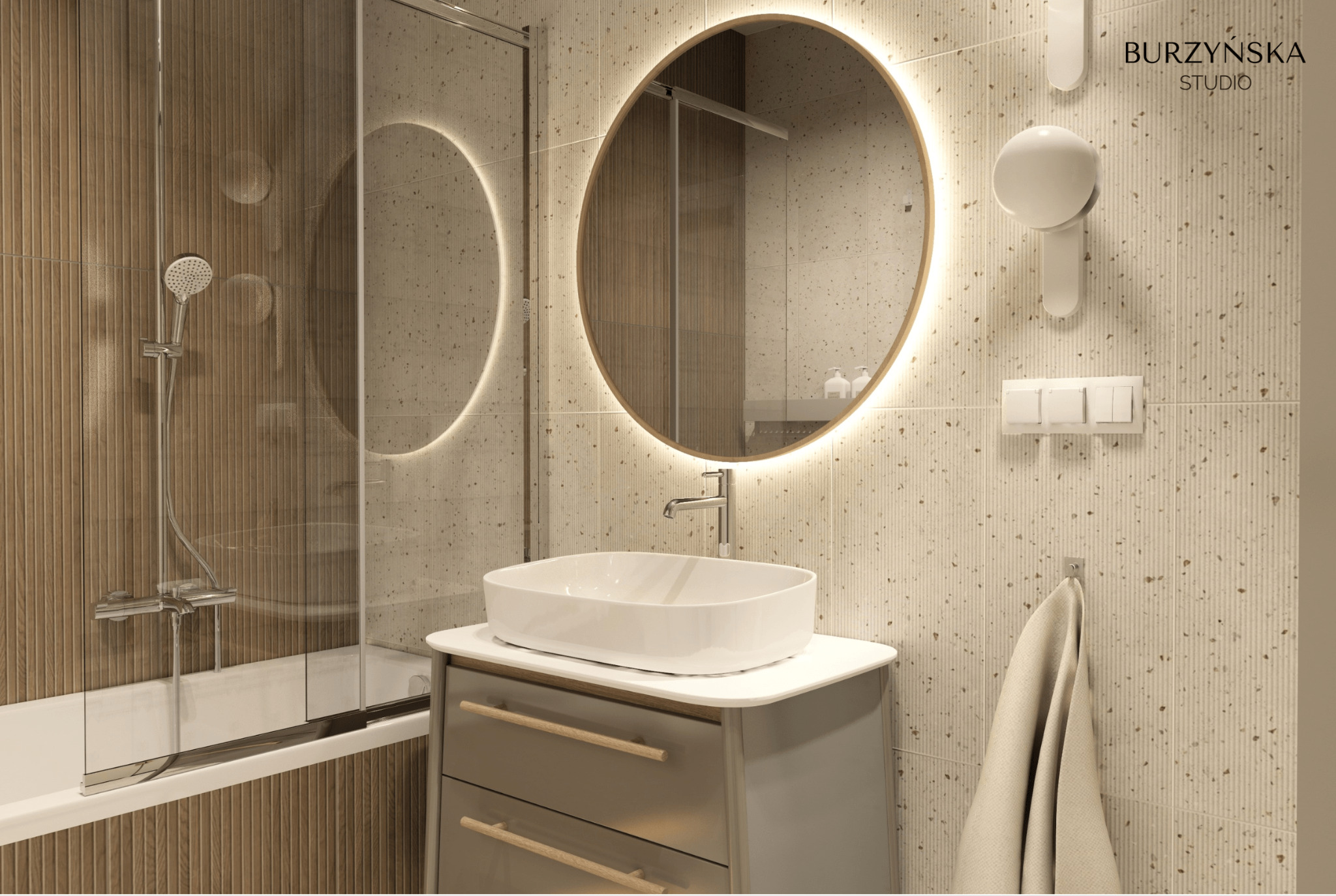 Nowoczesna łazienka z okrągłym lustrem z podświetleniem LED, umywalką nablatową na szafce z szufladami, prysznicem za szklaną ścianką i beżowymi płytkami z delikatnym wzorem.