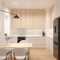 Jasna kuchnia z drewnianymi szafkami górnymi, białymi szafkami dolnymi, stołem jadalnym z czterema krzesłami z szarej tkaniny, czarną lampą ścienną i czarną lodówką.