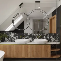 Nowoczesna łazienka na poddaszu ze skośnym sufitem, marmurową mozaiką na ścianie, podwójną umywalką nablatową, drewnianą szafką pod umywalką, okrągłymi lampami wiszącymi i kabiną prysznicową ze...