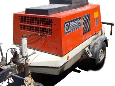 Pomarańczowa maszyna do wylewania posadzek miksokretem na przyczepie, z widocznym logo 'Estrich Boy'.