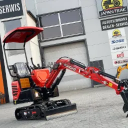 Czerwono-czarna minikoparka EXCAT prezentowana przed budynkiem autoryzowanego dealera Japan-Trak, widoczne logo marek Mikann, Solis, Iseki, Kioti, Oleo-Mac.