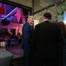 Zagroda Jutrzenki5- winnica, kuchnia, pikniki - Uczestnicy w strojach wieczorowych rozmawiają podczas imprezy integracyjnej w sali z dekoracjami świetlnymi i balonami.