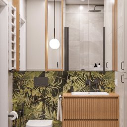 NOWA HATA SPÓŁKA Z OGRANICZONĄ ODPOWIEDZIALNOŚCIĄ - Nowoczesna łazienka w Warszawie z toaletą, umywalką na szafce z lamelami i lustrem. Ściana z motywem roślinnym dodaje wnętrzu unikalnego charakteru.