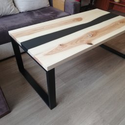 Stolik z blatem z drewna Jesionu i czarnej żywicy w środkowej czesci. Nogi ze stali malowane proszkowo. 