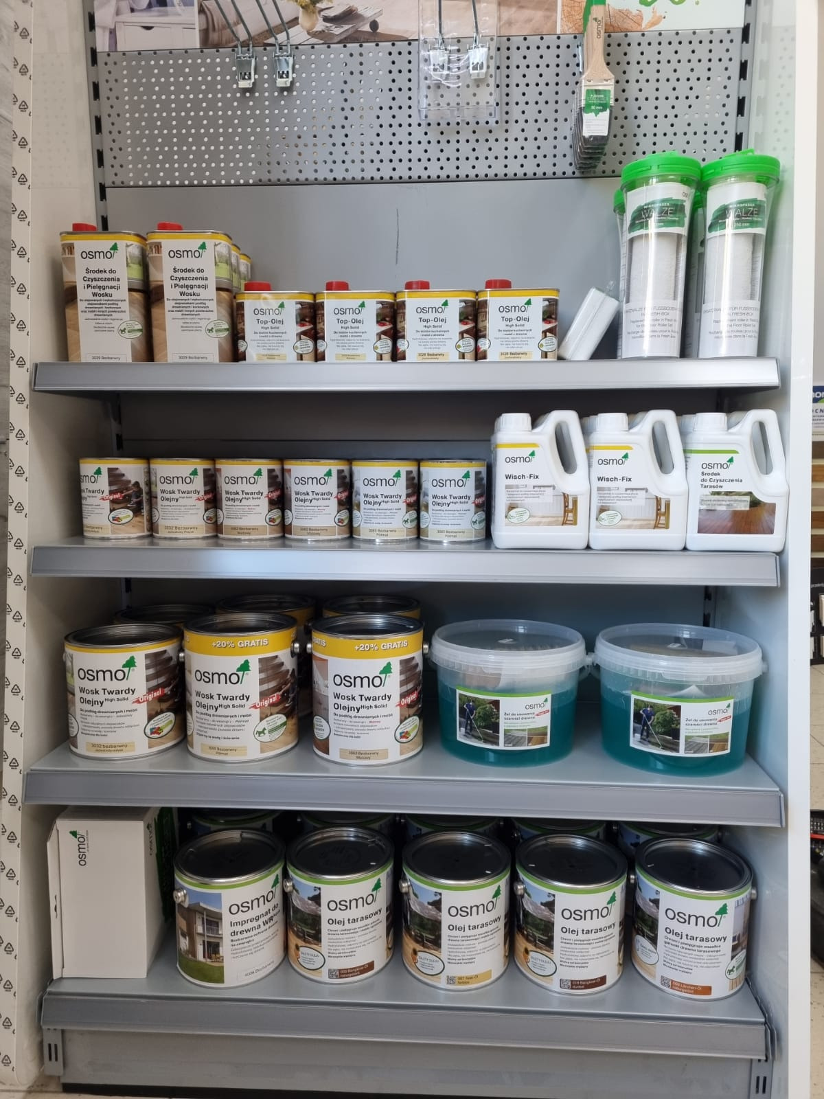 Półki w sklepie z produktami Osmo do pielęgnacji drewna: oleje, woski, impregnaty i środki czyszczące do podłóg i tarasów.