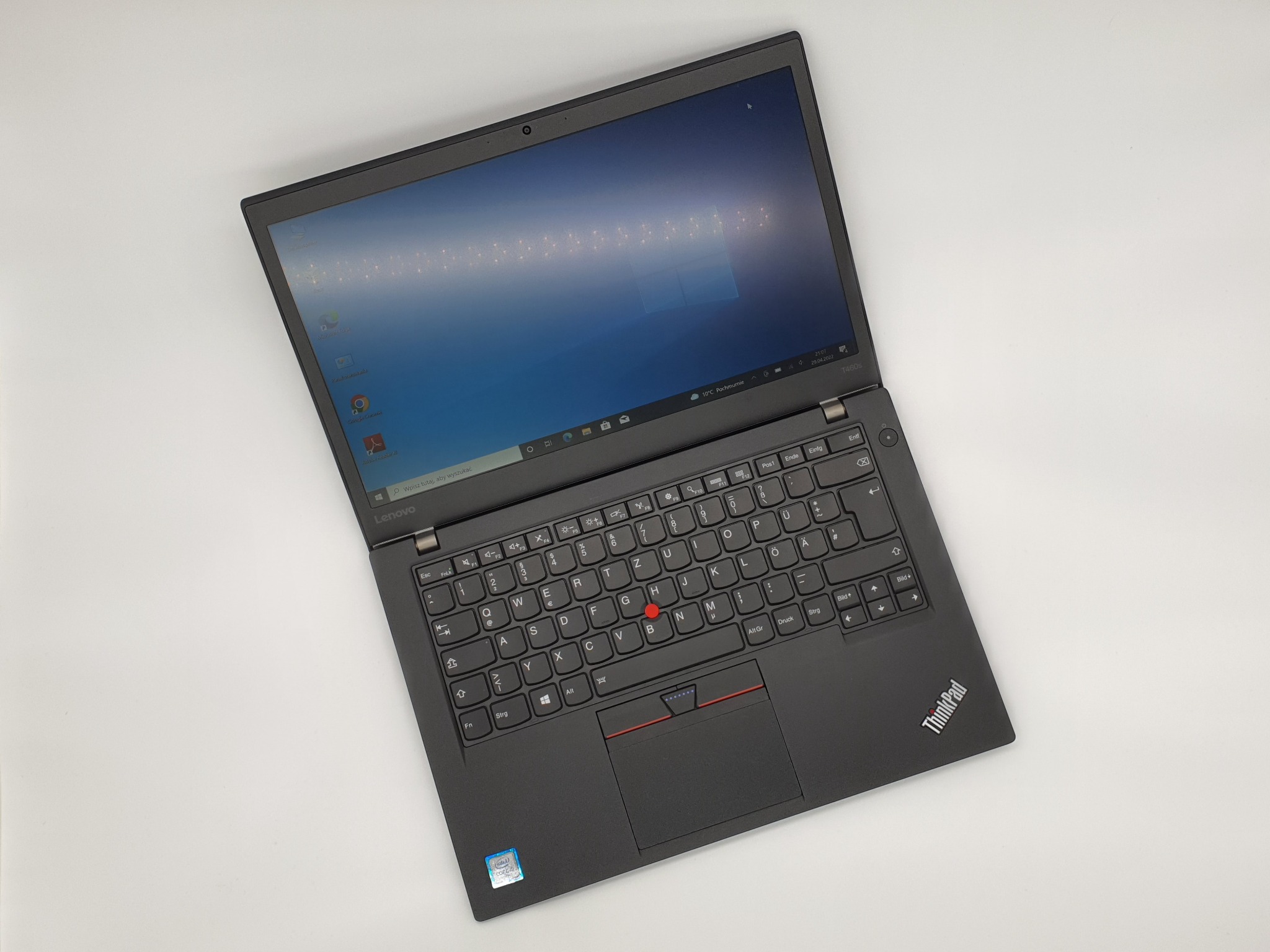 Otwarty laptop Lenovo ThinkPad T460s na białym tle, widoczny ekran z systemem Windows, klawiatura QWERTZ z czerwonym trackpointem i logo ThinkPad w prawym dolnym rogu.