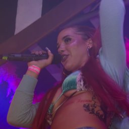 Fotografia koncertowa — dynamiczne ujęcie sceniczne z gry świateł i dymu. Kadr ukazuje energię występu i emocje artystki.