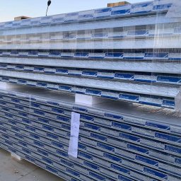 Marpanel sp z.o.o. - Stos płyt warstwowych marki GOR-STAL, zabezpieczonych folią, na paletach, z widocznym logo producenta, składowanych na zewnątrz.