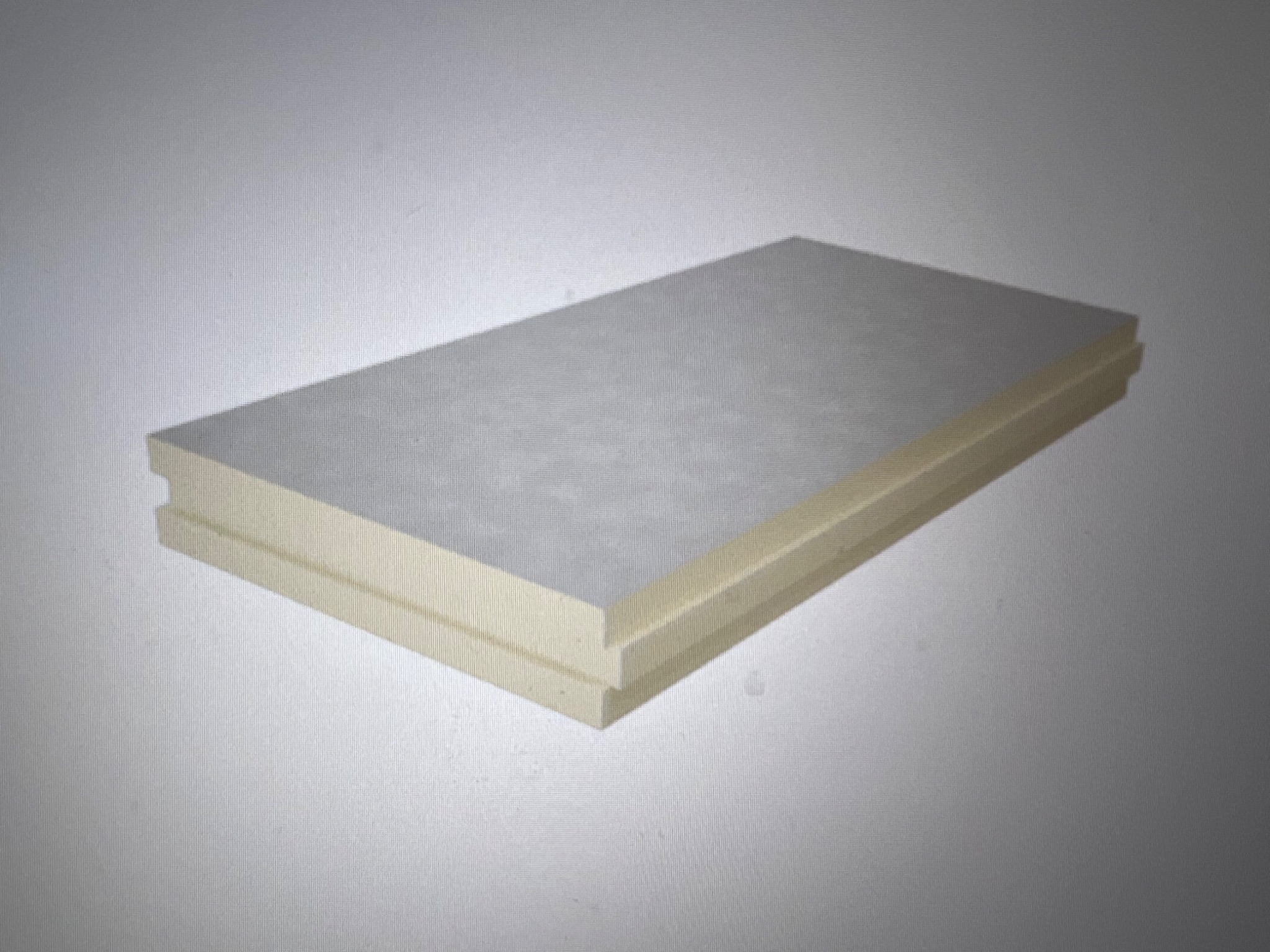 Dwa panele izolacyjne z jasnego styropianu, ułożone jeden na drugim, z wyraźnym frezem na krawędziach, na jednolitym, szarym tle.