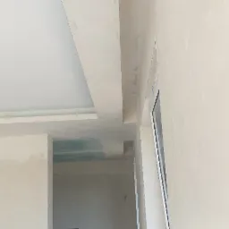 Sufit podwieszany z płyt karton-gips, widoczne łączenia wymagające szpachlowania, surowy stan wykończenia wnętrza z widocznymi instalacjami elektrycznymi.