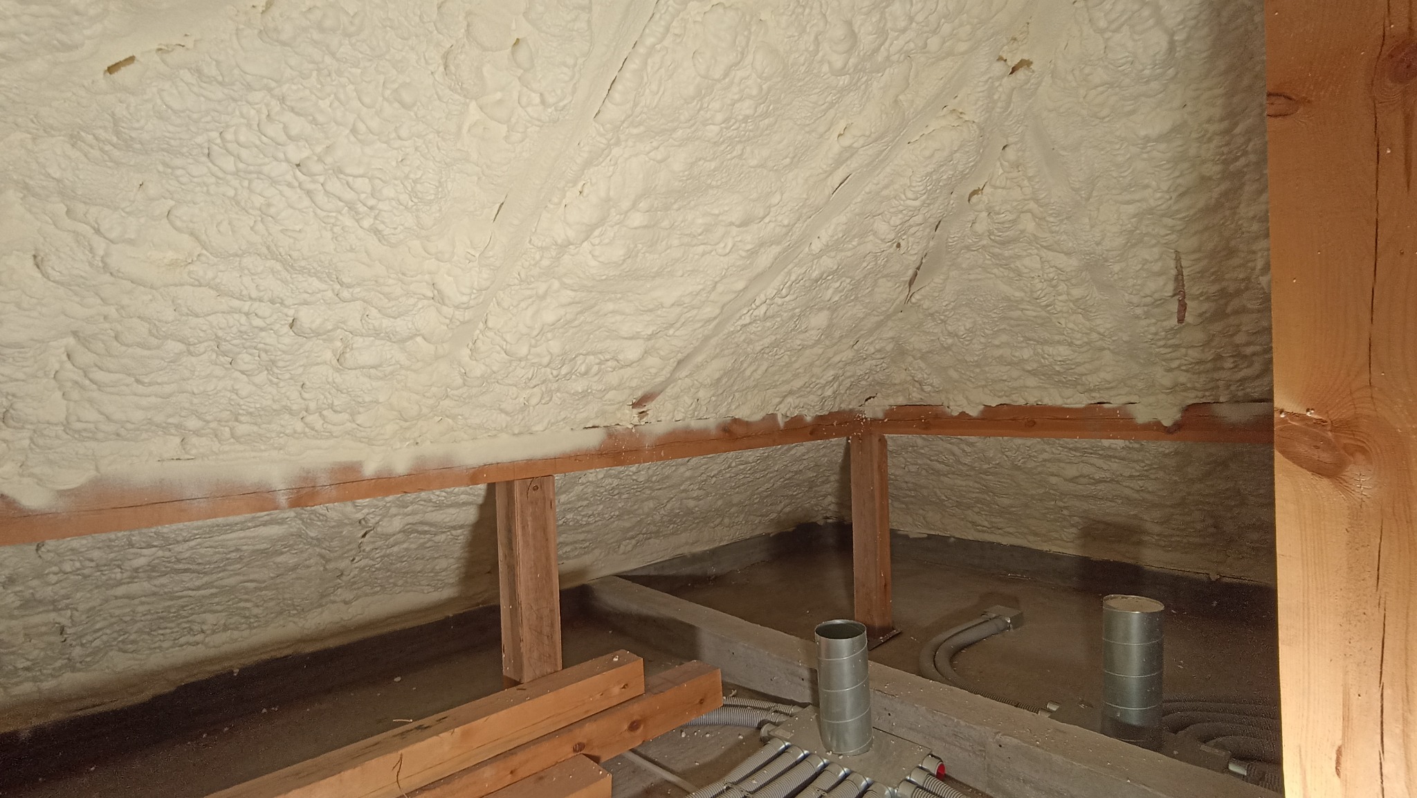 Poddasze w Serocku po izolacji pianką, widoczne drewniane elementy konstrukcyjne i instalacje wentylacyjne