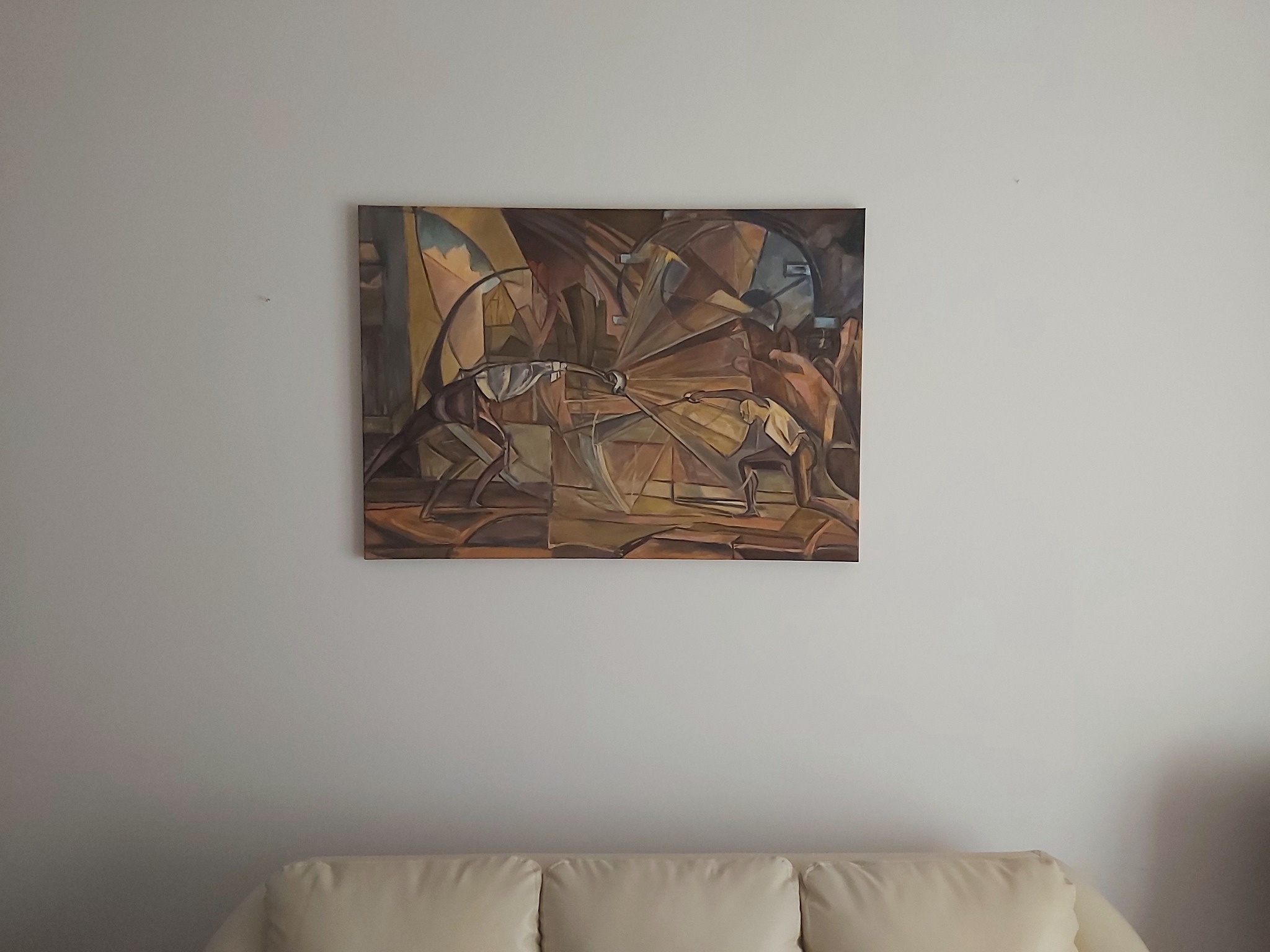 Abstrakcyjna kompozycja malarska przedstawiająca dwóch szermierzy w dynamicznej walce, utrzymana w ciepłej, brązowo-beżowej tonacji, wisząca na jasnej ścianie nad kremową kanapą.