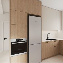 Nowoczesna kuchnia z drewnianymi frontami, białymi szafkami wiszącymi i czarną armaturą. Widoczny piekarnik Bosch i lodówka Hisense. Minimalistyczny design z widokiem na zieleń.