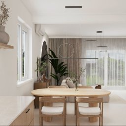 Pro Invest Black&White Aranżacja Wnętrz - Jasne wnętrze z drewnianym stołem i krzesłami, minimalistycznymi lampami wiszącymi i roślinami. Widok na salon z dużym oknem i zasłonami.