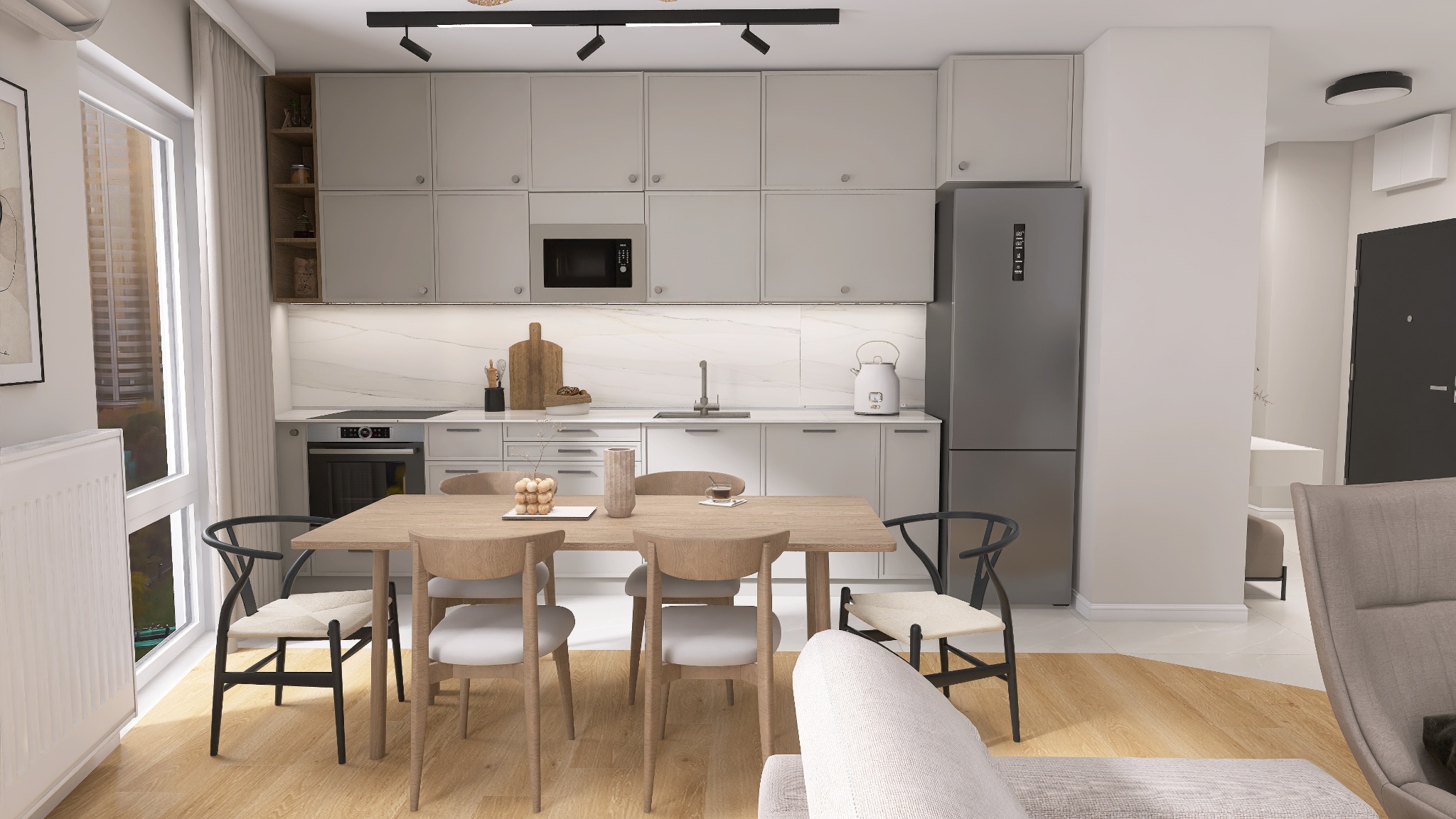 Jasna kuchnia w minimalistycznym stylu z drewnianym stołem i krzesłami, widok na zabudowę kuchenną z szarymi szafkami i marmurowym blatem, oświetlenie punktowe pod szafkami.