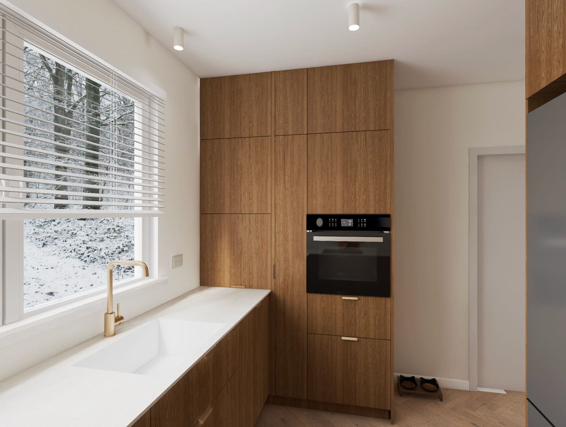 Nowoczesna kuchnia z drewnianymi szafkami, białym blatem i złotą armaturą. Za oknem zimowy krajobraz. Uwagę przykuwają minimalistyczne lampy sufitowe.