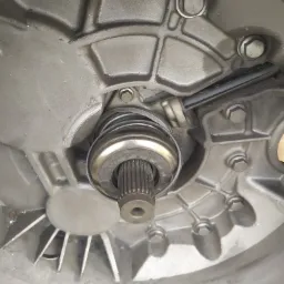 Szczegółowe ujęcie łożyska oporowego sprzęgła zamontowanego w skrzyni biegów, widoczne ślady smaru i zabrudzenia.