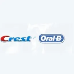 Logotypy marek Crest i Oral-B na jasnym, rozmytym tle.