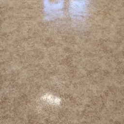 Wypolerowana podłoga z wzorem w odcieniach beżu i brązu, odbijająca światło, z widocznymi listwami przypodłogowymi i fragmentem grzejnika.