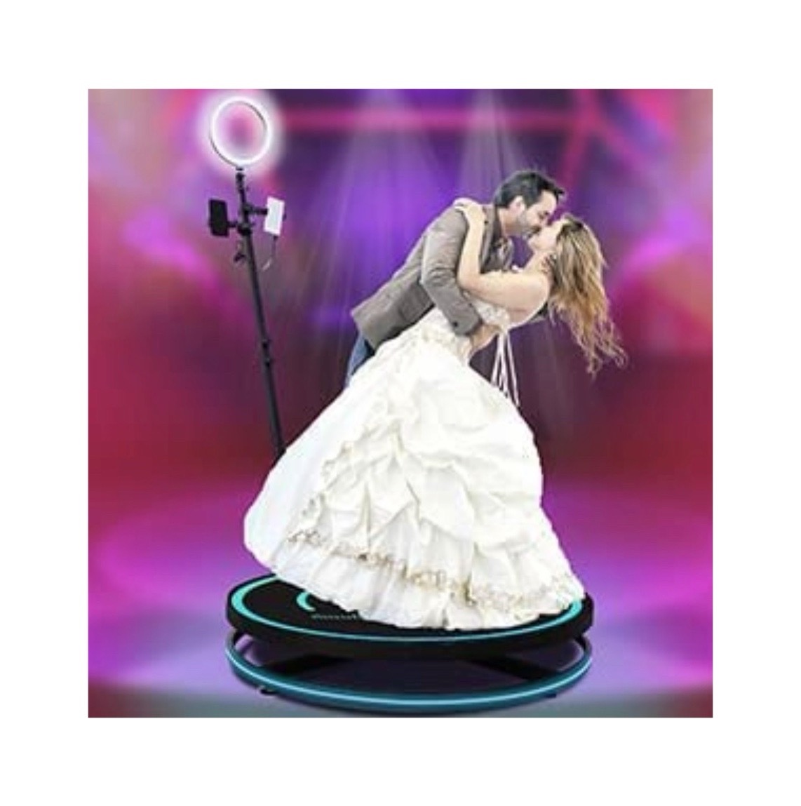 Para w objęciach na platformie obrotowej z oświetleniem LED i smartfonem na statywie, w tle kolorowe światła sceniczne.