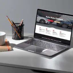 Laptop na biurku z wyświetloną stroną internetową 'Auto Moto Ekspert', obok kubek, notatnik z gumką i metalowy pojemnik z długopisami i ołówkami.