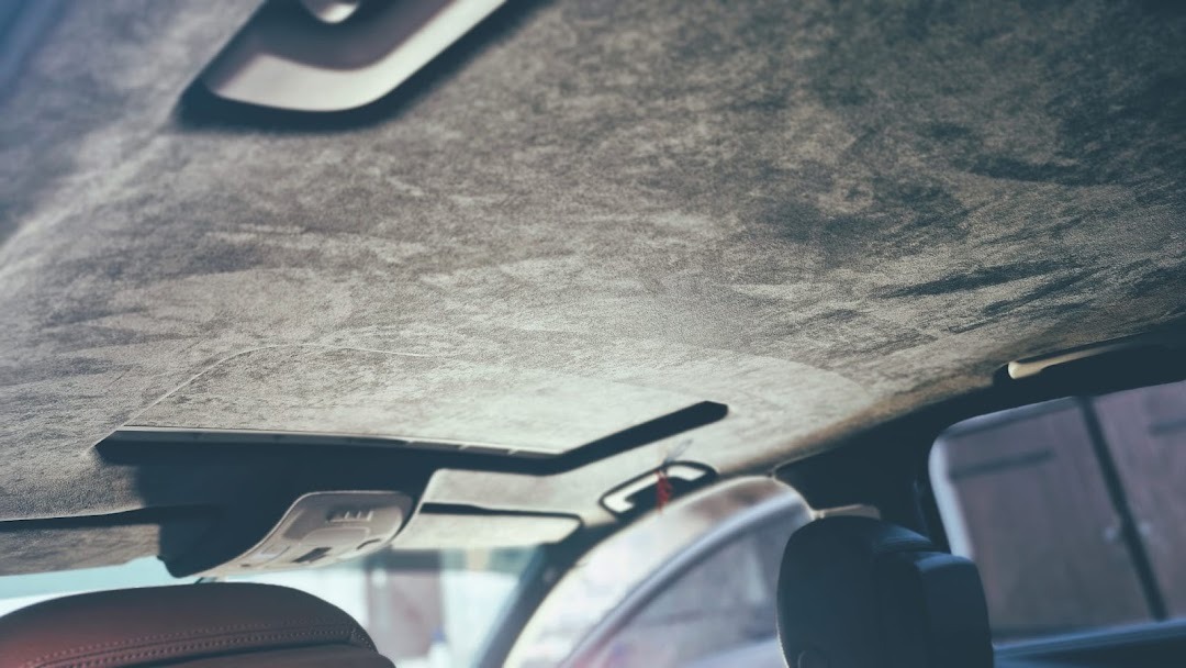 Wnętrze samochodu z nową podsufitką z ciemnej alcantary, widok z Nasielska, z widocznym oknem dachowym.