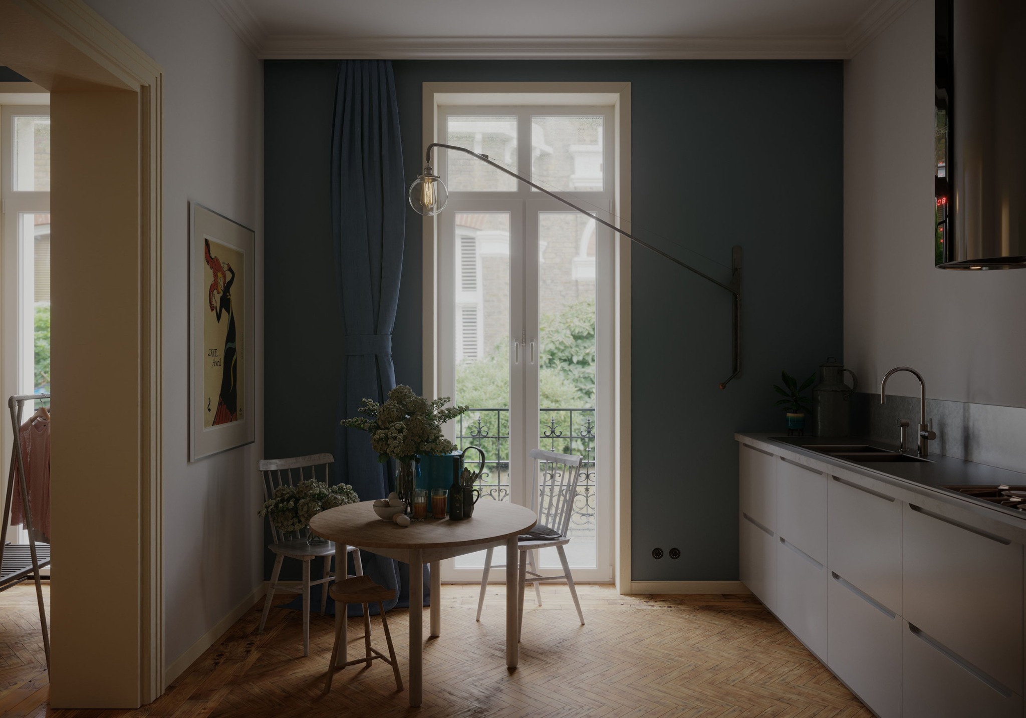 Jasna kuchnia z parkietem w jodełkę, okrągłym drewnianym stołem z kwiatami i jajkami, oraz minimalistyczną zabudową kuchenną z ciemnym blatem i metalowym okapem