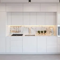 Nowoczesna, minimalistyczna kuchnia z białymi, lakierowanymi frontami, marmurowym blatem i złotymi akcentami, oświetleniem LED pod szafkami górnymi, oraz sprzętem AGD w zabudowie.