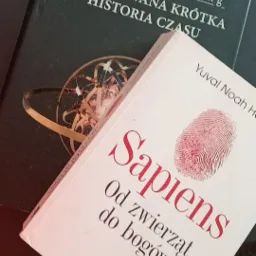 Dwie książki: 'Ilustrowana krótka historia czasu' Stephena Hawkinga i 'Sapiens. Od zwierząt do bogów' Yuvala Noaha Harariego, leżące na drukarce.