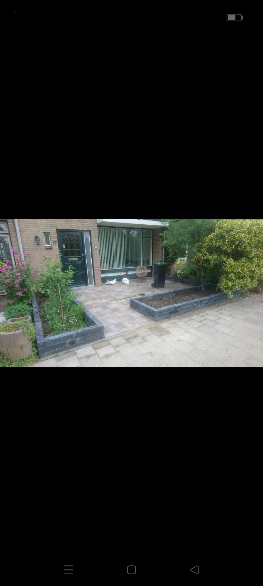 Ułożona kostka brukowa na podjeździe i obrzeża rabat kwiatowych z szarej kostki w Benthuizen.