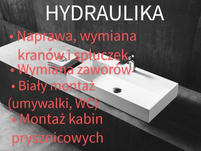 Umywalka ceramiczna o prostokątnym kształcie z zamontowaną baterią, ułożona na blacie z ciemnego kamienia, obok leży złożony szary ręcznik. W tle ściana imitująca ciemny kamień.