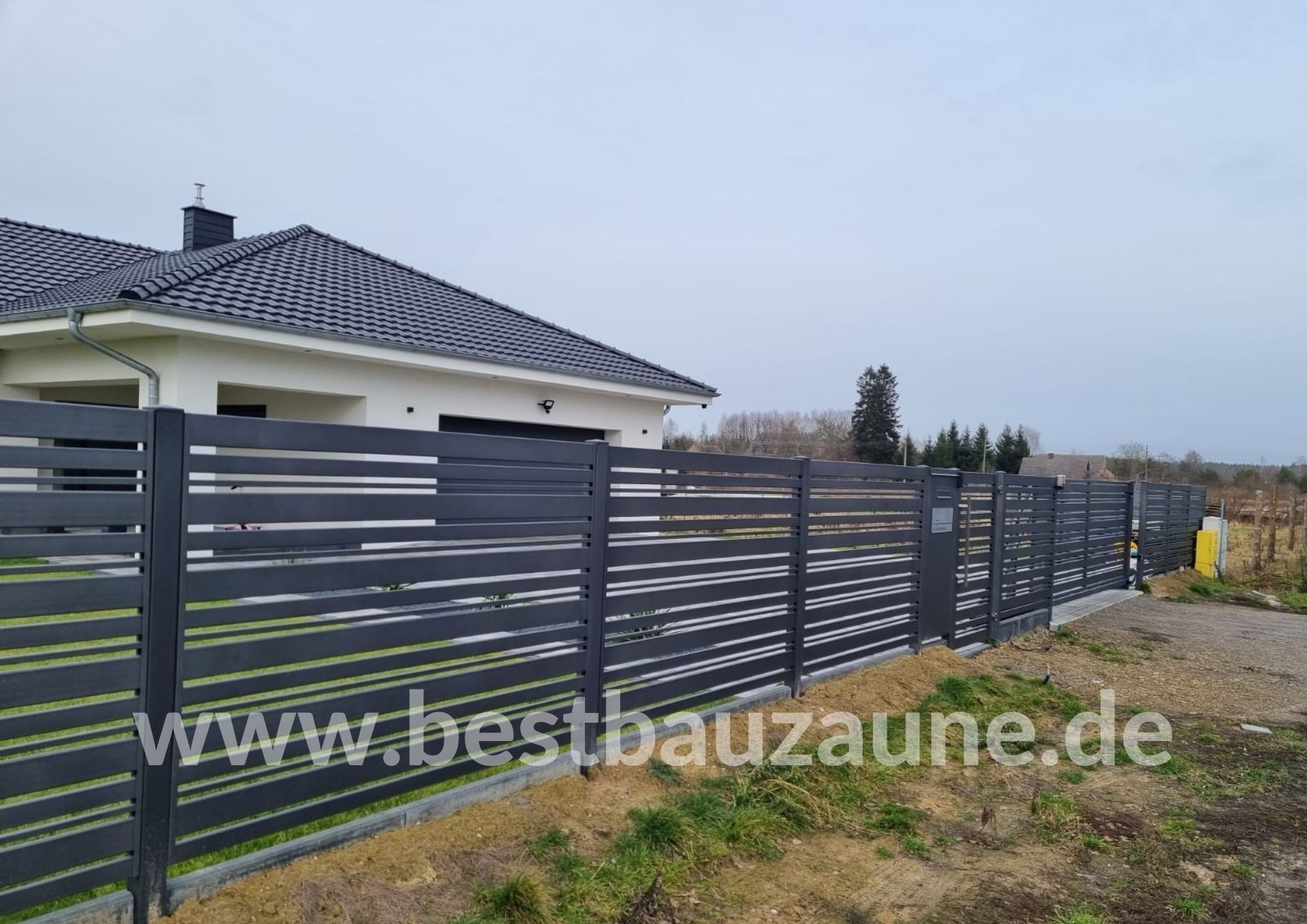 Nowoczesne, poziome przęsła ogrodzeniowe w kolorze grafitowym, z widocznym domem jednorodzinnym w tle