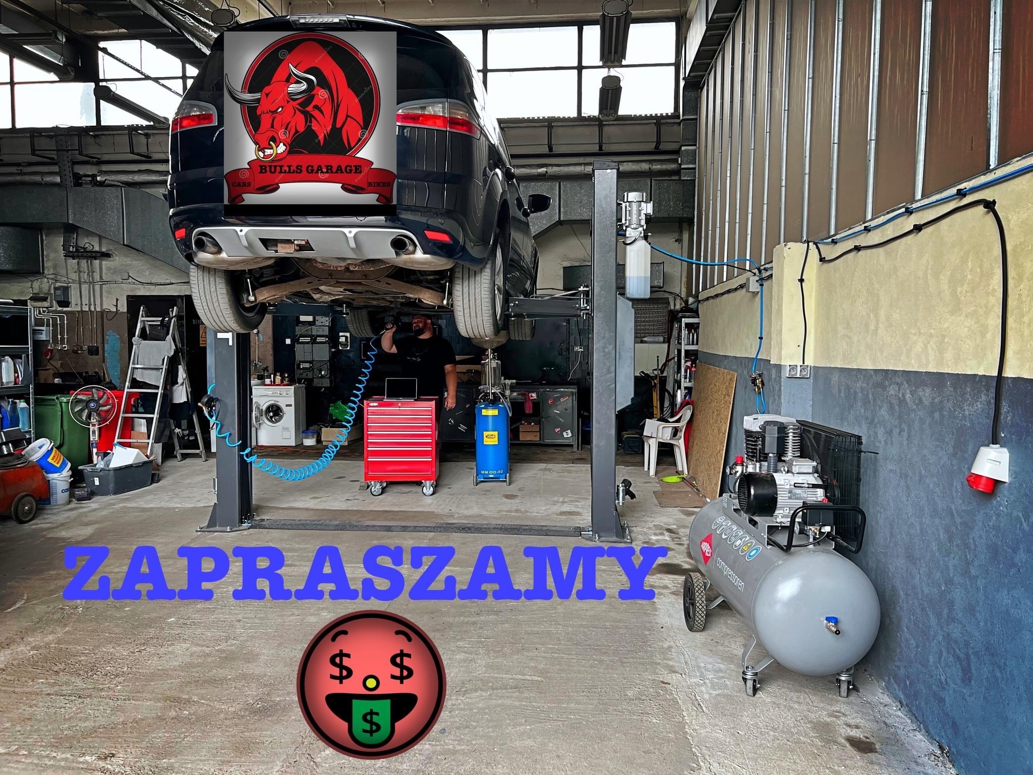 Samochód na podnośniku w warsztacie, widoczny pracownik pod autem, obok czerwona skrzynka narzędziowa i kompresor. Na tylnej szybie auta naklejka z logotypem firmy.