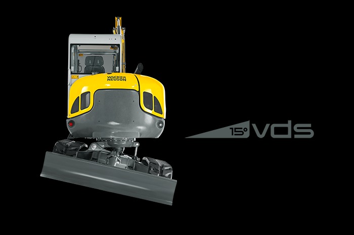 Żółto-szara minikoparka Wacker Neuson z przodu, na czarnym tle z napisem '15° vds'.