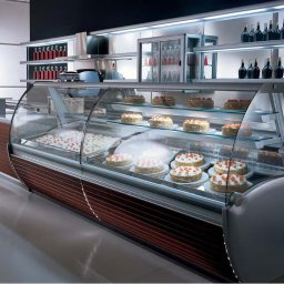 MEGAR Sp. z o.o. - Profesjonalna przeszklona witryna chłodnicza z ciastami i deserami, podświetlone półki, butelki z napojami na górnych półkach, nowoczesny design.