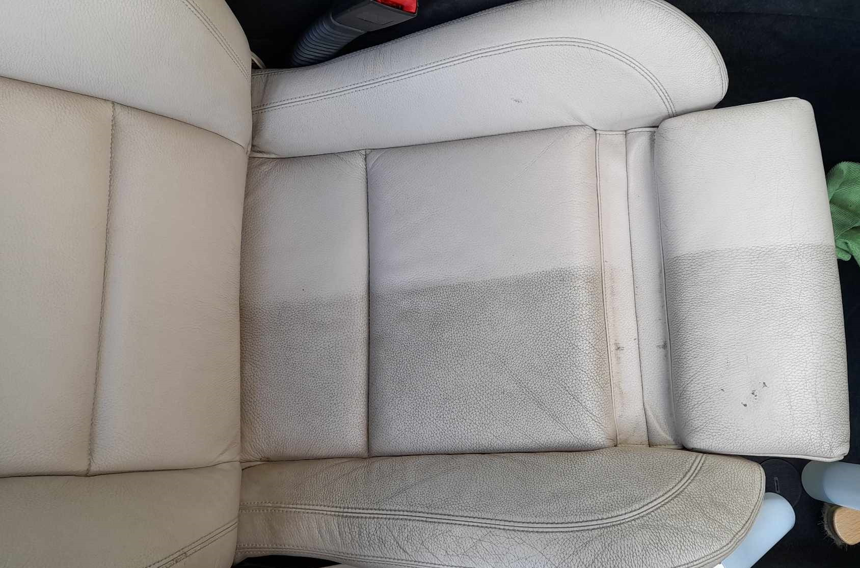 Jasna skórzana tapicerka samochodowa, widoczna różnica w czystości między wypraną a nie wypraną częścią fotela, ukazująca skuteczność czyszczenia.