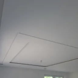 Nowoczesny sufit podwieszany z elementami dekoracyjnymi w Grudziądzu, widok z dołu, białe wykończenie.