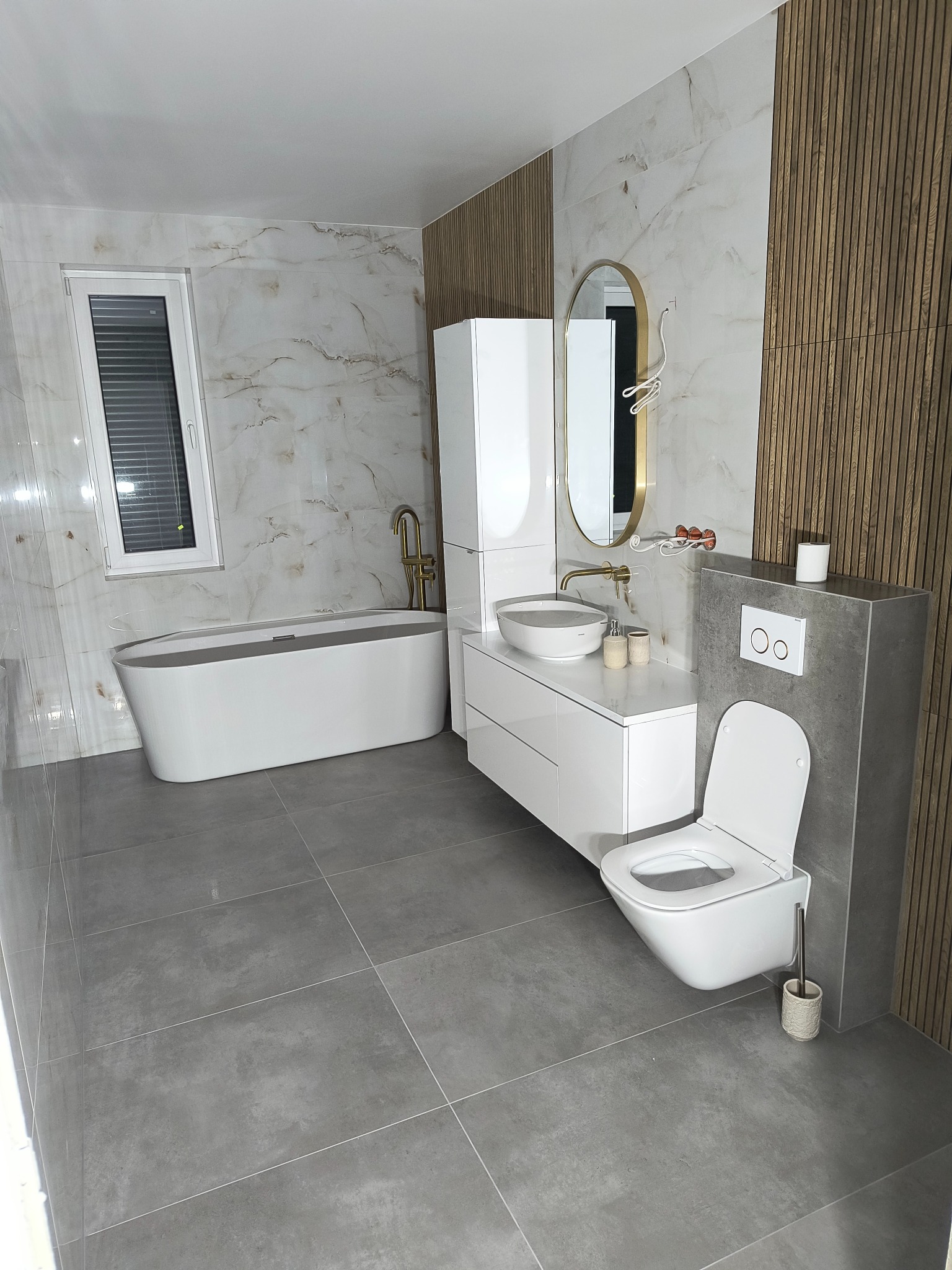 Nowoczesna łazienka z wanną wolnostojącą, umywalką nablatową i WC podwieszanym. Marmurowe płytki i drewniane panele ścienne tworzą elegancki wystrój.