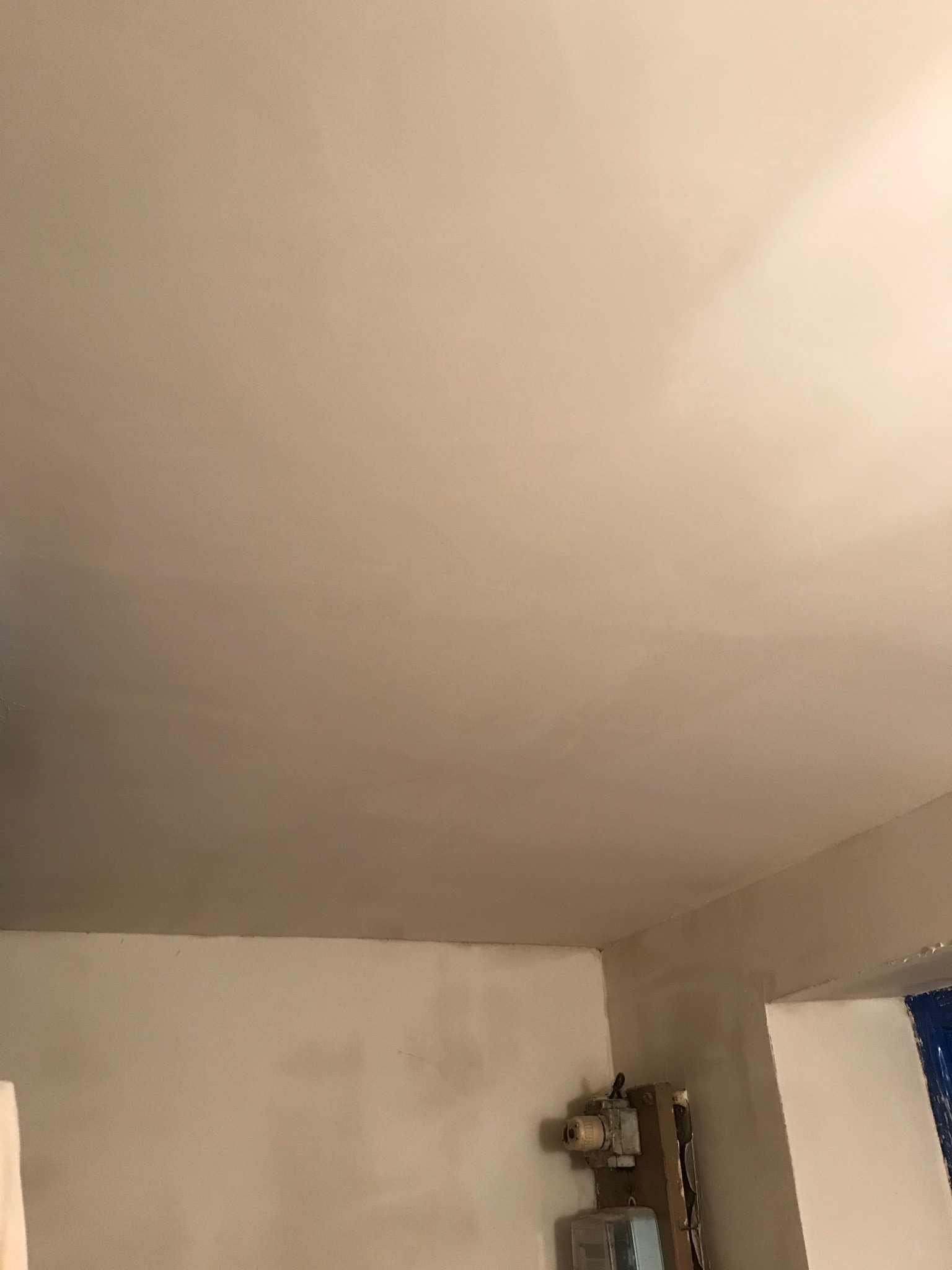 Wnętrze mieszkania w Warszawie po malowaniu, widoczny odnowiony sufit i ściany, z elementami instalacji elektrycznej w rogu.