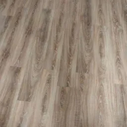 Ułożone panele podłogowe w odcieniach jasnego brązu z widoczną strukturą drewna, sfotografowane pod kątem z bliska.